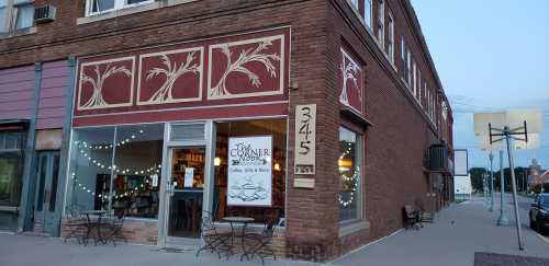 A cozy bookstore and coffee shop with outdoor seating, featuring a brick facade and decorative window designs.