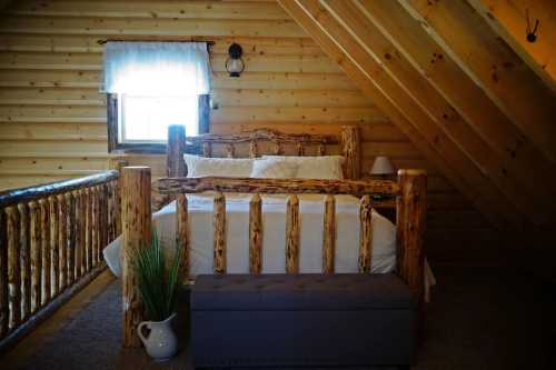 Cozy attic bedroom with a wooden bed, rustic decor, and a view through a window.