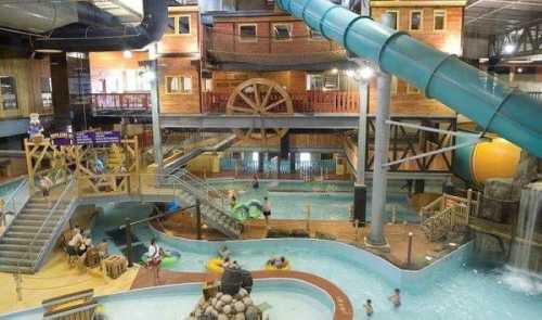 Indoor water park featuring slides, a lazy river, and various play areas with families enjoying the attractions.