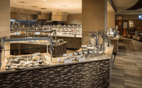A buffet setup featuring various dishes on a granite counter in a modern dining area.