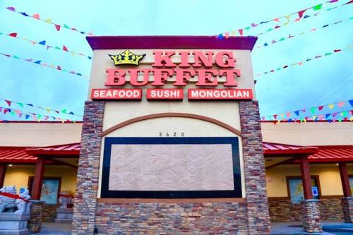 Exterior of King Buffet restaurant featuring a colorful sign and decorative banners.