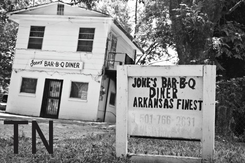 A black and white photo of Jones Bar-B-Q Diner, a two-story building with a sign proclaiming "Arkansas's Finest."