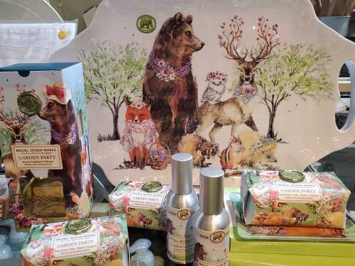 A decorative tray featuring a bear, deer, and fox among flowers, surrounded by themed garden party products.