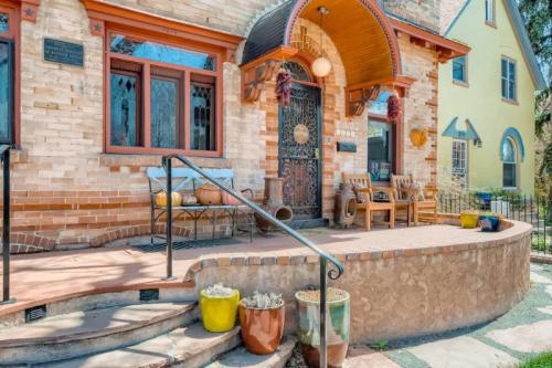 Charming brick house entrance with decorative arch, steps, and potted plants. Cozy seating area visible.