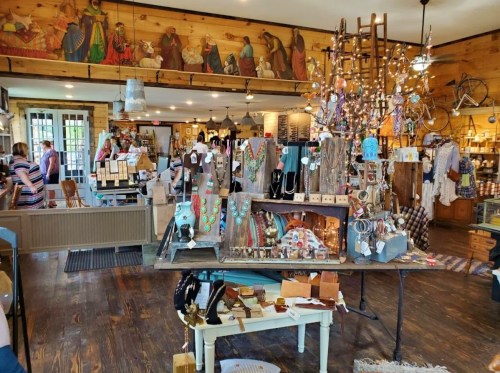 A cozy shop filled with handmade jewelry, crafts, and decor, featuring wooden walls and warm lighting.