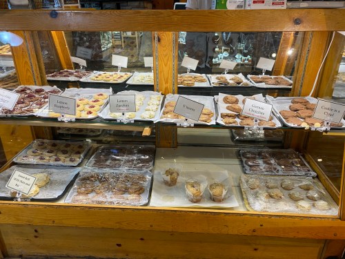 A display case filled with various baked goods, including cookies and pastries, labeled with names.