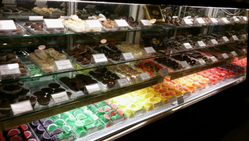 A display case filled with an assortment of colorful chocolates and candies in various shapes and sizes.