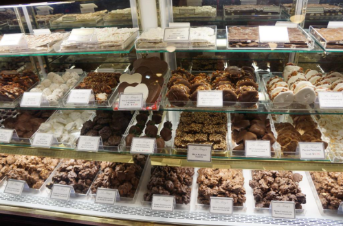 A display case filled with various chocolates and confections, including fudge, truffles, and chocolate-covered treats.