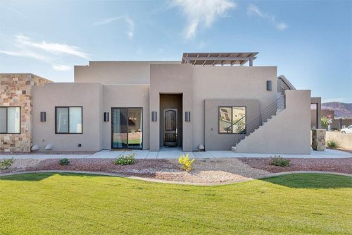 Modern single-story home with a landscaped yard and a staircase leading to a rooftop terrace.