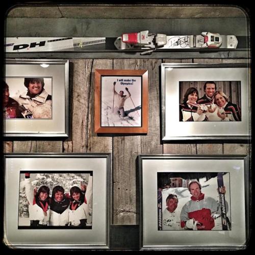 A collage of framed ski photos and memorabilia, including a motivational quote about making the Olympics.