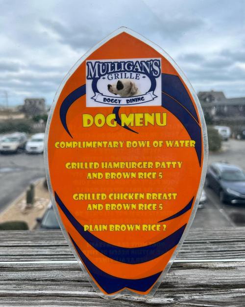 Sign for Mulligan's Grille dog menu featuring items like grilled hamburger patty, chicken breast, and complimentary water.