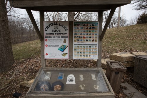 Sign for Crystal Lake Cave Mining Company with displays for gemstones, fossils, and panning instructions.
