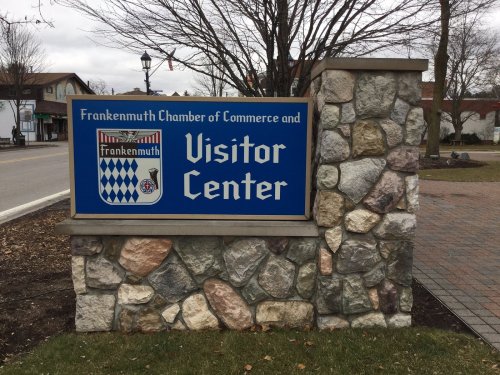Sign for the Frankenmuth Visitor Center, featuring a stone base and blue background with white text.