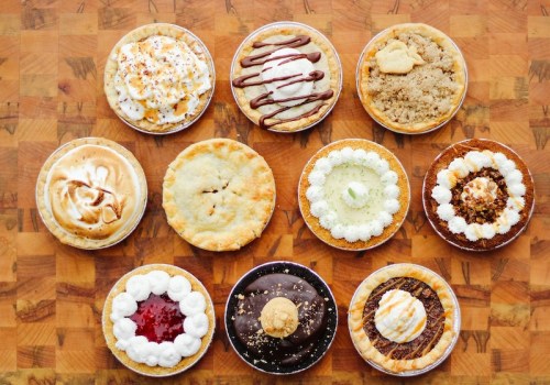 A variety of delicious pies arranged on a wooden surface, featuring different toppings and flavors.