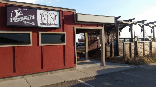 Exterior of Pheasant Restaurant & Lounge, featuring a sign and entrance, with a patio area visible in the background.