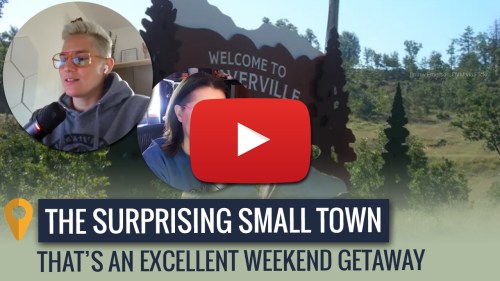 A video thumbnail featuring two people discussing a small town getaway, with a "Welcome" sign in the background.