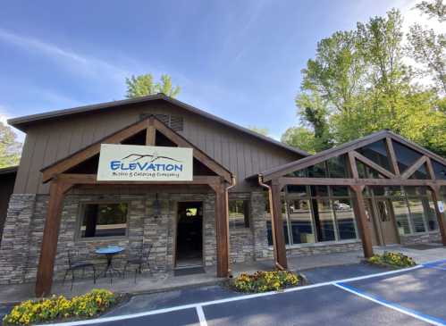 A rustic building with a stone facade and wooden beams, featuring a sign for "Elevation Biking & Gliding Company."