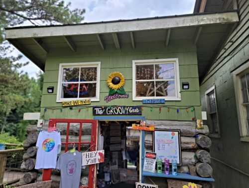 A colorful storefront with a sunflower sign, open windows, and a welcoming entrance featuring various signs and merchandise.