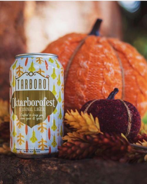 A can of Tarboro Oktarborofest seasonal lager next to a decorative pumpkin and autumn leaves.