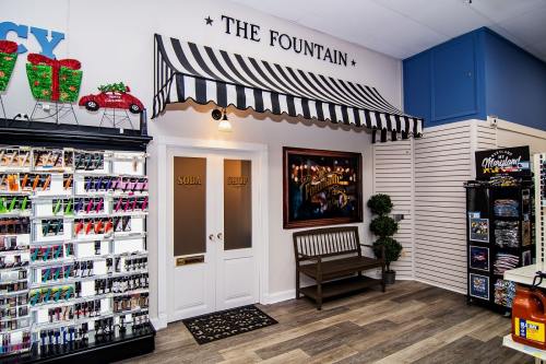 A cozy shop entrance with a striped awning, bench, and colorful product displays on the left.