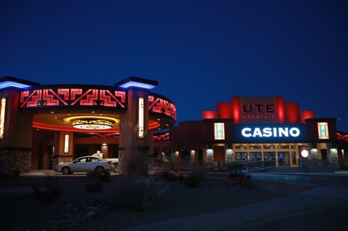 Exterior of Ute Mountain Casino at night, featuring bright neon lights and a modern architectural design.