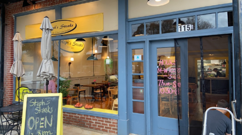 Exterior of Steph's Steaks restaurant with a sign indicating open hours and a welcoming atmosphere.