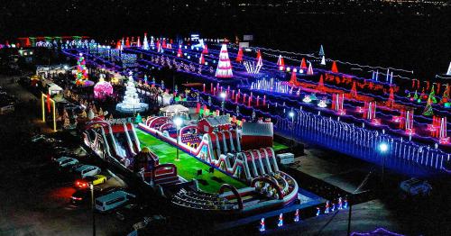 Aerial view of a vibrant night fair with colorful lights, inflatable attractions, and festive decorations.