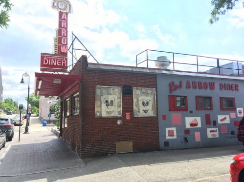 Exterior of the Red Arrow Diner, featuring a retro sign and colorful murals on the building's facade.