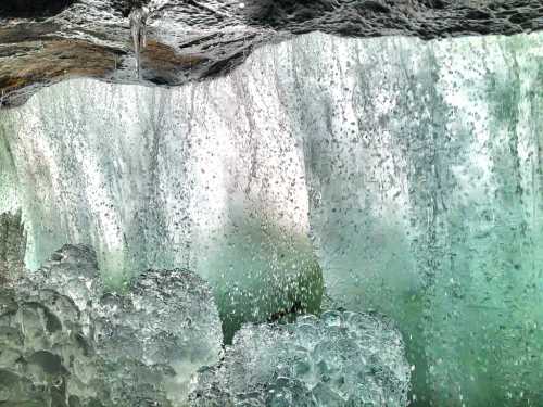 A close-up view of cascading water, creating bubbles and a misty, translucent effect.