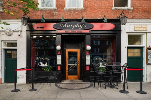 Exterior of Murphy's restaurant with a red and black facade, outdoor seating, and a welcoming entrance.