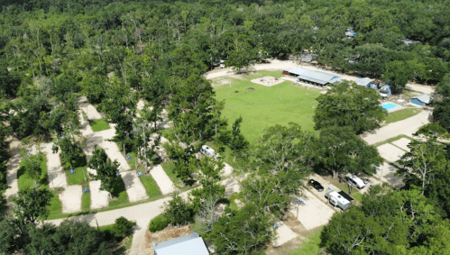 Aerial view of a campground with grassy areas, trees, and several RV sites and amenities.