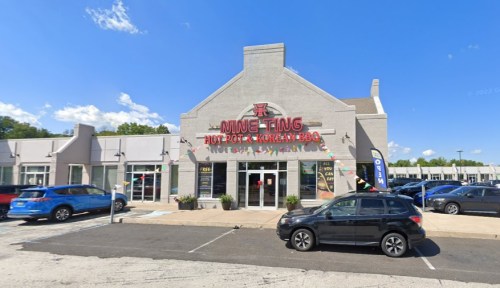 Exterior of Ning Ting Hot Pot & Korean BBQ restaurant, featuring a gray building with colorful signage and parked cars.