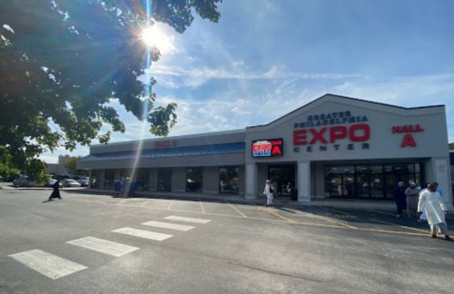 Exterior view of the Greater Philadelphia Expo Center, featuring large signage and a clear blue sky.