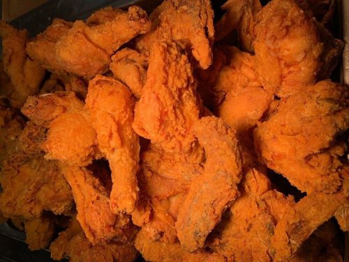 A close-up of a large pile of crispy, golden-brown fried chicken wings.