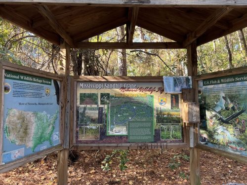 Information kiosk featuring maps and details about the Mississippi Sandhill Crane National Wildlife Refuge and trails.