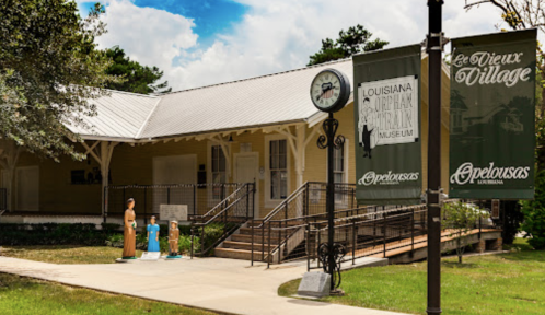 Exterior of the Louisiana Outback Park Museum in Opelousas, featuring a clock and sculptures of people.