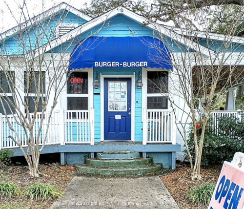 A blue and white restaurant with a sign reading "Burger-Burger" and an open sign in the window.