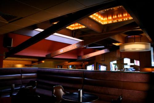 Interior of a modern restaurant with warm lighting, wooden accents, and cozy seating arrangements.
