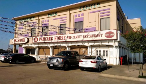 Exterior of a restaurant with a sign reading "Pancake House and Family Restaurant," featuring a parking lot and colorful building.