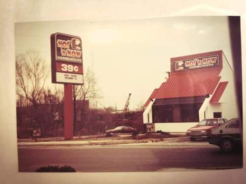 A vintage fast-food restaurant with a red roof and a sign advertising hamburgers for 39 cents.