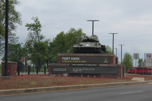 Sign for Fort Knox with a tank on display, surrounded by trees and a road, indicating "Strength Starts Here."