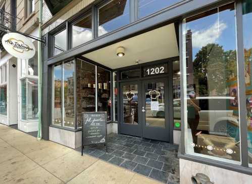 A storefront with large glass windows, featuring a sign that reads "1202" and a chalkboard menu outside.