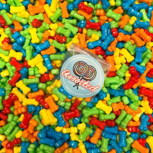 A colorful assortment of plastic dog bone-shaped toys scattered around a package labeled "Cannified."
