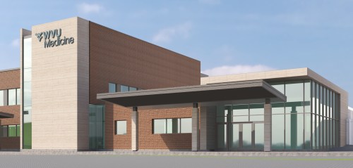 Modern medical building with a glass entrance and brick facade, featuring the WVU Medicine logo prominently displayed.