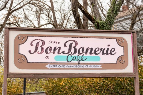 Sign for Bon Bonerie Café with decorative lettering, indicating entrance via Madison Rd or garden.
