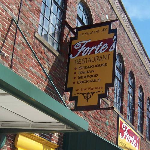 Sign for Forte's Restaurant, featuring steakhouse, Italian, seafood, and cocktails, on a brick building.
