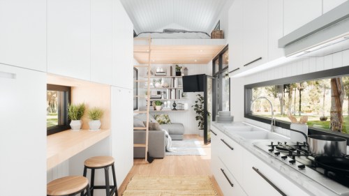 A modern tiny home interior featuring a kitchen, living area, and a lofted sleeping space with natural light.