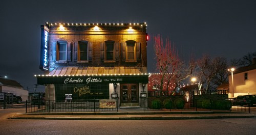 A charming restaurant exterior at night, adorned with lights and a welcoming "Open" sign.