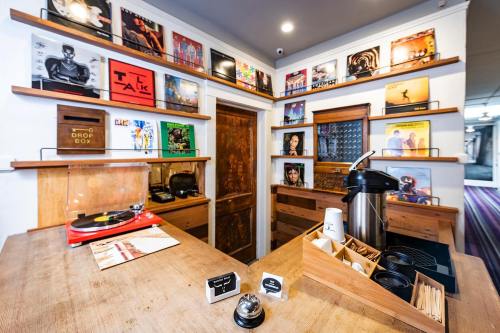 A cozy record shop interior with vinyl records on shelves, a turntable, and a coffee station on a wooden counter.