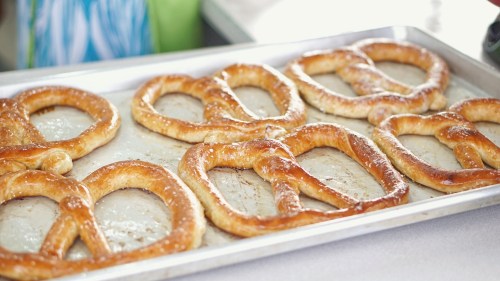 A tray of freshly baked, golden-brown pretzels arranged neatly.